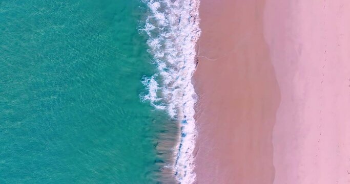 4K DCI 4096x2160p. Top-down view aerial beach video Ocean waves roll onto the beautiful beach. Filmed with high quality cinema cameras. DCI 4K ProRes422