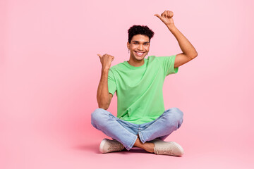 Full length photo of satisfied nice man dressed stylish t-shirt pants directing at promo empty space isolated on pink color background