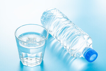 青背景にペットボトルと水の入ったグラス