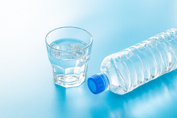 青背景にペットボトルと水の入ったグラス
