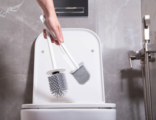 The girl in her hand holds three silicone brushes for the toilet. The concept of care and hygiene...