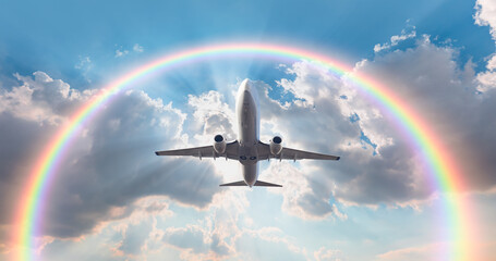Airplane in the sky with amazing rounded rainbow in the background stormy sky