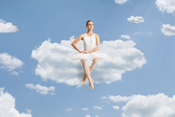 Beautiful ballerina sitting on a cloud