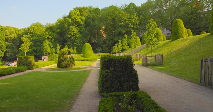 Pan shot of garden of Cumbre Abbey (Abbaye de La Cambre) on a sunny day. French classicism park with green vegetation in Brussels, Belgium on a sunny day.