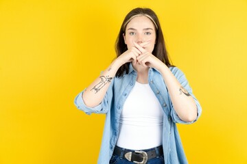 Young beautiful woman wearing denim overshirt Has rejection angry expression crossing fingers doing negative sign. - obrazy, fototapety, plakaty