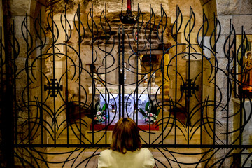 Woman praying in the crypt of the Annunciation Roman catholic basilica, Nazareth, Galilee, Israel.