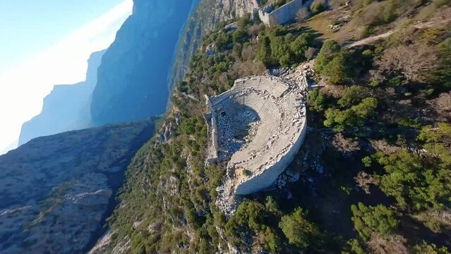 Bird's-eye view, drone circling over the ruins of an ancient amphitheater in the mountains. Termessos Turkey