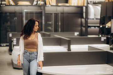 Woman choosing bath in bath shwroom, building materials