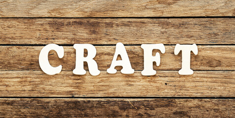 The word Craft written on wood letters on wooden background, top view.