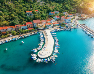 Aerial view of boats and luxury yachts, buildings at summer sunset. Beautiful city Baska, Krk island, Croatia. Colorful landscape with sailboats and motorboats, architecture, sea bay, jetty. Top view