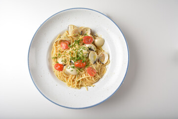 stir fried olive oil mixed seafood clam shell pasta in aglio olio style and cherry tomato pesto in...