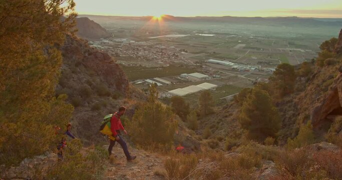 Two mountaineers discussing the route to follow, they watch the sun rising in the distance, Orihuela, Alicante, Spain - stock video