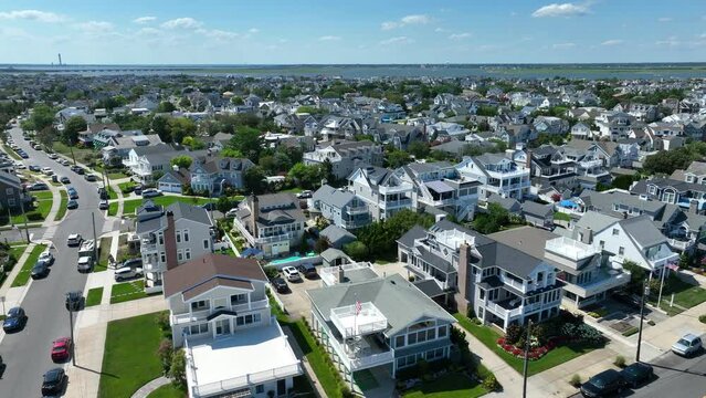 Beach town in USA. Aerial shot of expensive houses, homes, rentals, and Airbnb. Beautiful summer day in neighborhood at beach.