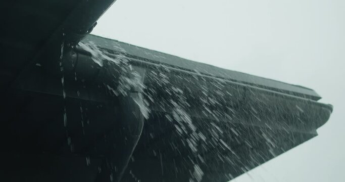 Streams of water pour from the roof over the drainage system.