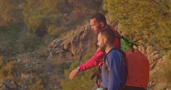 Two mountaineers discussing the route to follow, they watch the sun rising in the distance, Orihuela, Alicante, Spain - stock video