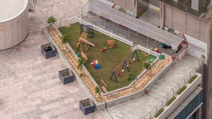 Colorful children playground activities on a rooftop garden aerial timelapse.
