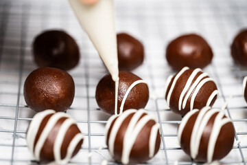 Making and decorating delicious homemade sweet balls with dark and white chocolate.