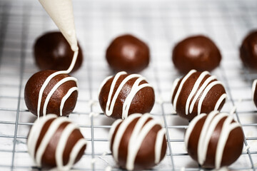 Making and decorating delicious homemade sweet balls with dark and white chocolate.