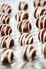 Making and decorating delicious homemade sweet balls with dark and white chocolate.