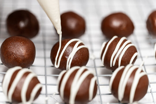 Making and decorating delicious homemade sweet balls with dark and white chocolate.