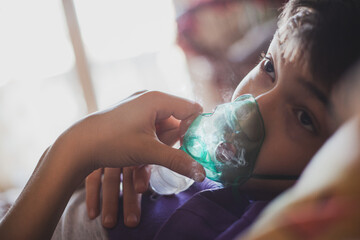 A teenage boy uses an allergy and asthma inhaler