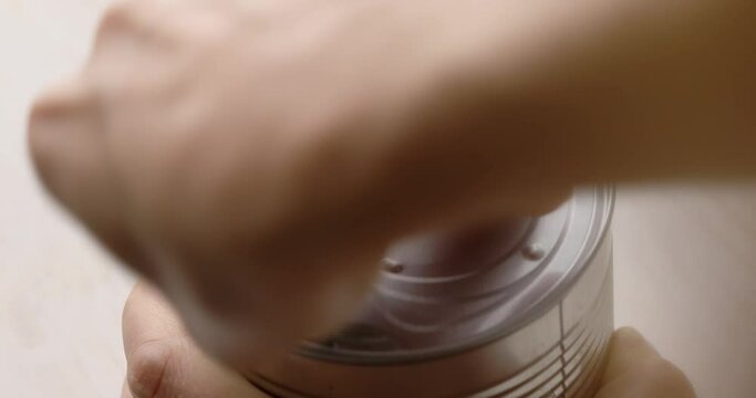 Women's hands open a can of corn. Food preparation with canned vegetables. A series of footage to visualize the recipe.