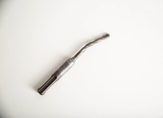 Poor quality broken metal drill on a white background, close-up