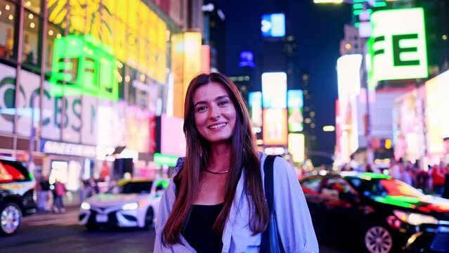 Portrait of happy Caucasian woman on Times Square, USA. Attractive cute girl smiling and looking at camera enjoying trip to America wearing fashionable clothes. Times Square concept.