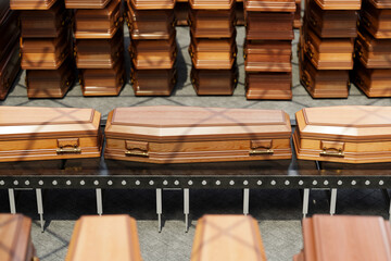 A row of coffins on the conveyor belt. Transportation of human remains.