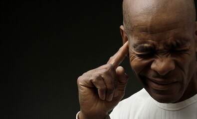 man suffering from deafness and hearing loss on grey background with people stock image stock photo	
