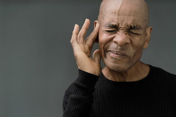 man suffering from deafness and hearing loss on grey background with people stock image stock photo	