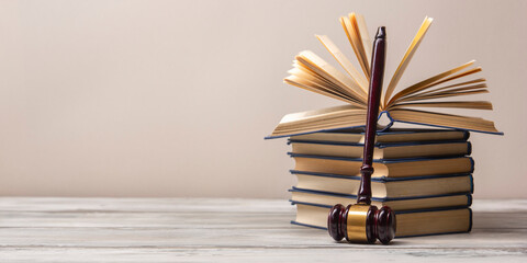 Legal Law and Justice concept - Open law book with a wooden judges gavel on table in a courtroom or law enforcement office. Copy space for text. - 643609244