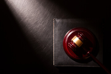 Legal Law and Justice concept - Open law book with a wooden judges gavel on table in a courtroom or law enforcement office. Copy space for text. - 643609262