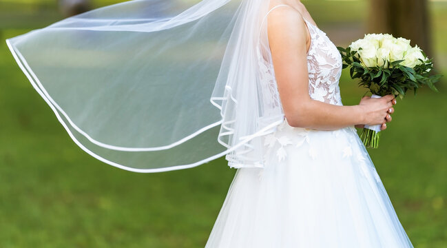 Bride holds the wedding bouquet of flowers
