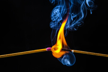 Fire and smoke. Burning and smoking match on a black background. Heat and light from fire flame