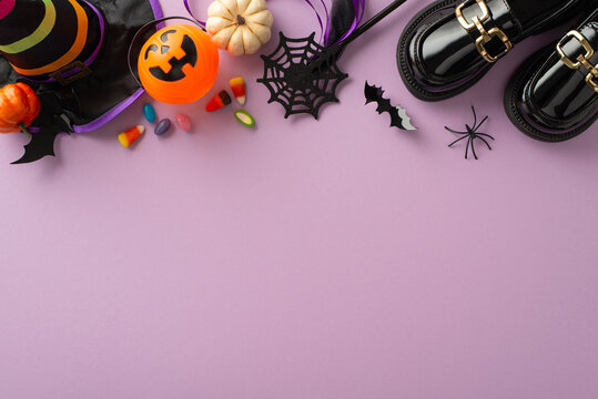 Delight in magic of Halloween trick-or-treating with this aerial image of kids' accessories and Halloween-themed decor on a violet isolated background, designed for advertisements or text insertion