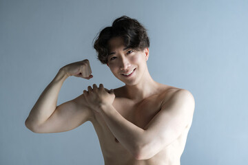 筋肉を鍛えるカッコイイハンサムな日本人男性　上腕二頭筋 カメラ目線