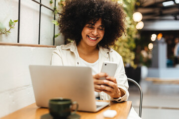 Happy woman browsing social media on her smartphone in coffee shop