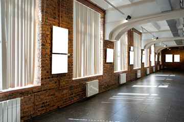 Blank picture frames on brown wall with glowing lamp, mock up