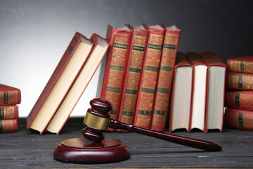 Legal Law and Justice concept - Open law book with a wooden judges gavel on table in a courtroom or law enforcement office. Copy space for text. - 643620034