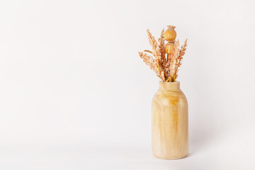 Autumn decor dried flowers in yellow wooden vase on white background. copy space