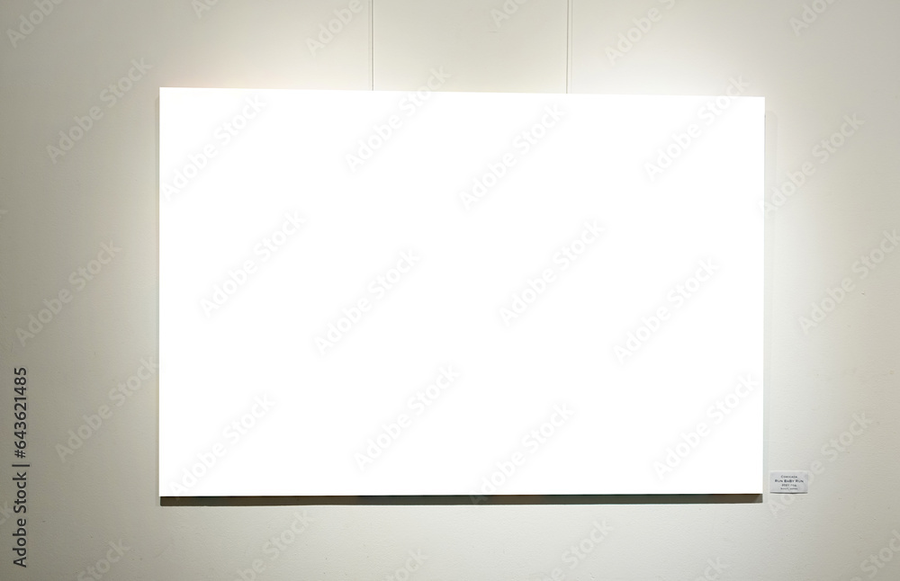 Wall mural blank picture frames on grey wall with glowing lamp, mock up