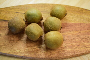 Several kiwi fruits on a wooden surface