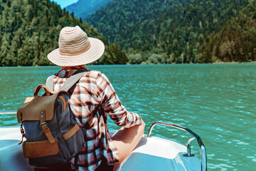 Hiking traveller woman with backpack enjoying beautiful view of turquois blue Lake Ritsa and...