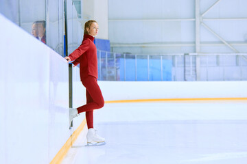 Fototapeta na wymiar Girl in red sportswear, figure skating athlete standing on ice rink area and preparing for training session. Concept of professional sport, competition, sport school, health, hobby, ad