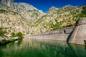Fototapeta na wymiar River canal and city walls of the fortress of the Kotor old town