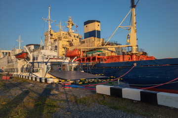 Obraz premium the stern parts of ships moored in the port. evening sunset. natural light