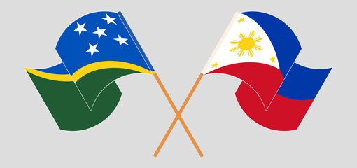 Crossed and waving flags of Solomon Islands and the Philippines