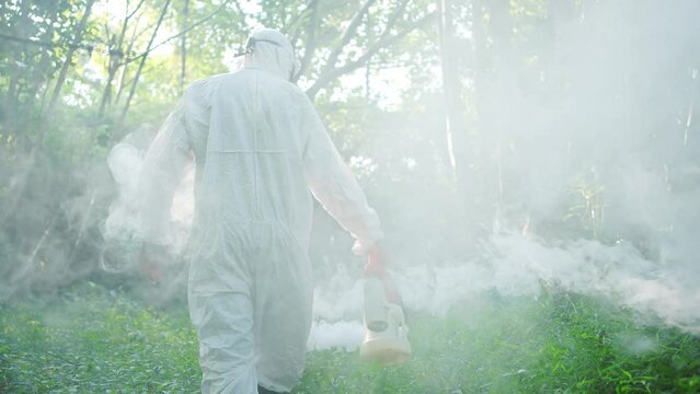 worker in uniform uses a mosquito fumigator to destroy the Zika virus and Dengue fever tick insect