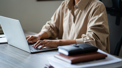 Female entrepreneur working with technology on laptop to typing financial data of startup project